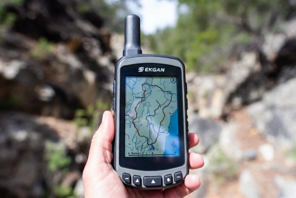 Handheld GPS showing dog location in rugged terrain, illustrating GPS trackers for hunting dogs in remote areas